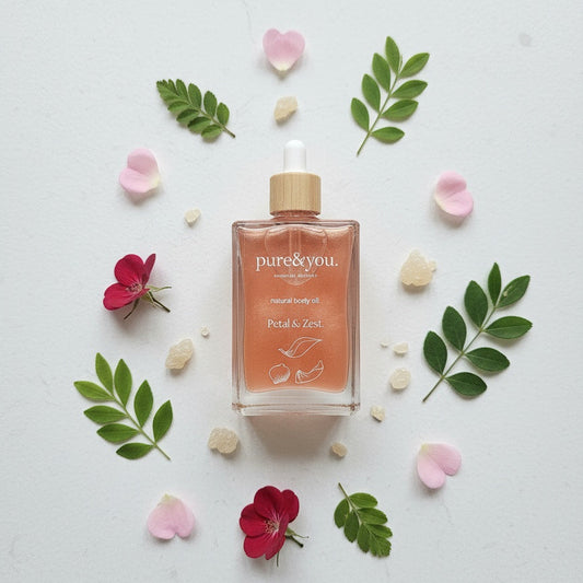 Bottle of 'pure&you' product surrounded by flowers and leaves on a light background